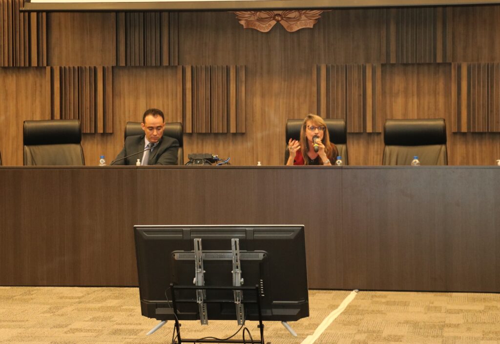 Fotografia horizontal colorida duas pessoas, um homem e uma mulher falando ao microfone. Legenda:  juiz Rodrigo Faria e juíza federal Vânila Cardoso André de Moraes
