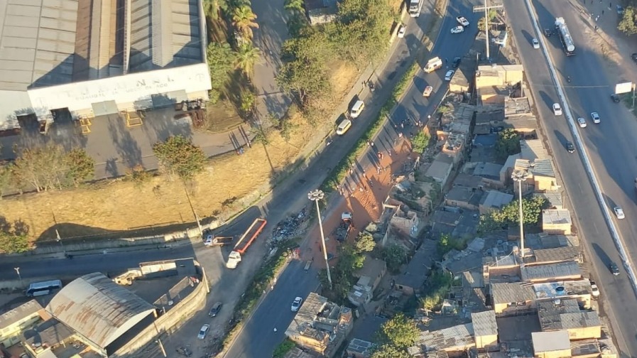 Foto horizontal colorida imagem aérea de um trecho moradias e pistas do Anel Rodoviário.
