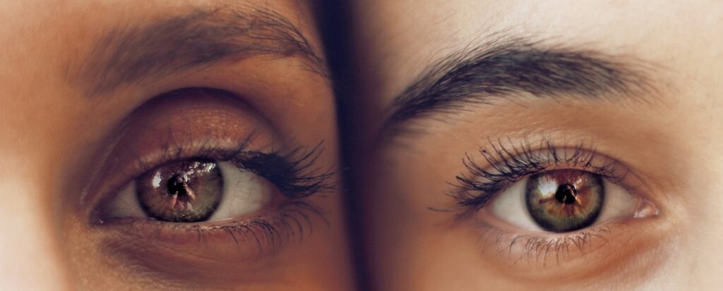 Fotografia retangular e colorida mostrando bem de perto os olhos de duas mulheres, uma ao lado da outra.