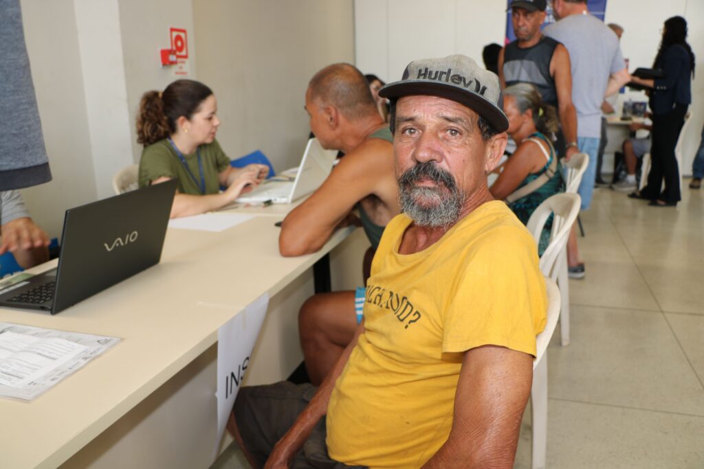 Fotografia colorida de um homem de camisa amarela e boné. Legenda: Luiz Carlos dos Santos, há dez anos morando nas ruas: "estou resolvendo tudo".