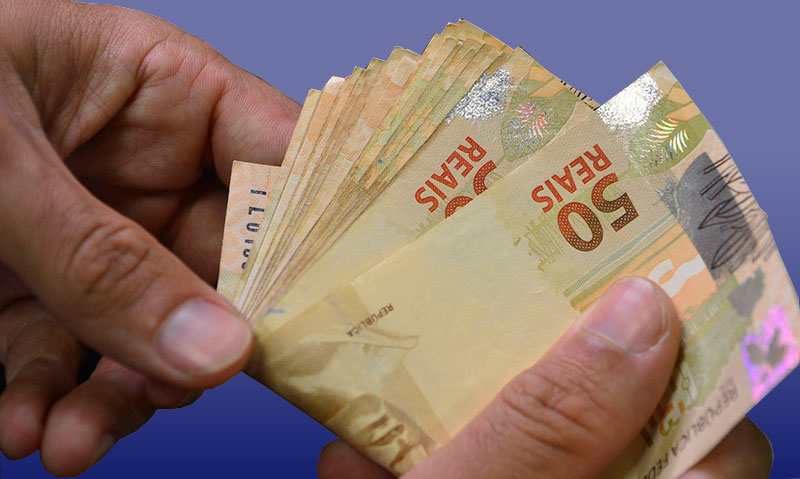Fotografia colorida das mãos de uma pessoa contando notas de R$50 reais.