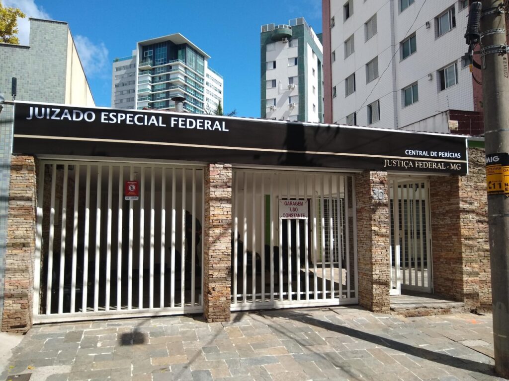Fotografia colorida e retangular da frente da Casa de Perícias, com três portas gradeadas.