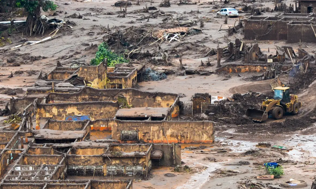 Fotografia colorida da vista de cima da cidade de mariana tomada pela lama após o rompimento da barragem.