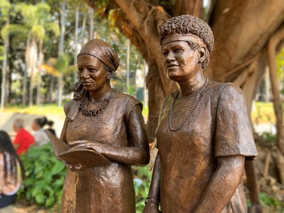 Fotografia colorida de duas estátuas de mulheres negras.