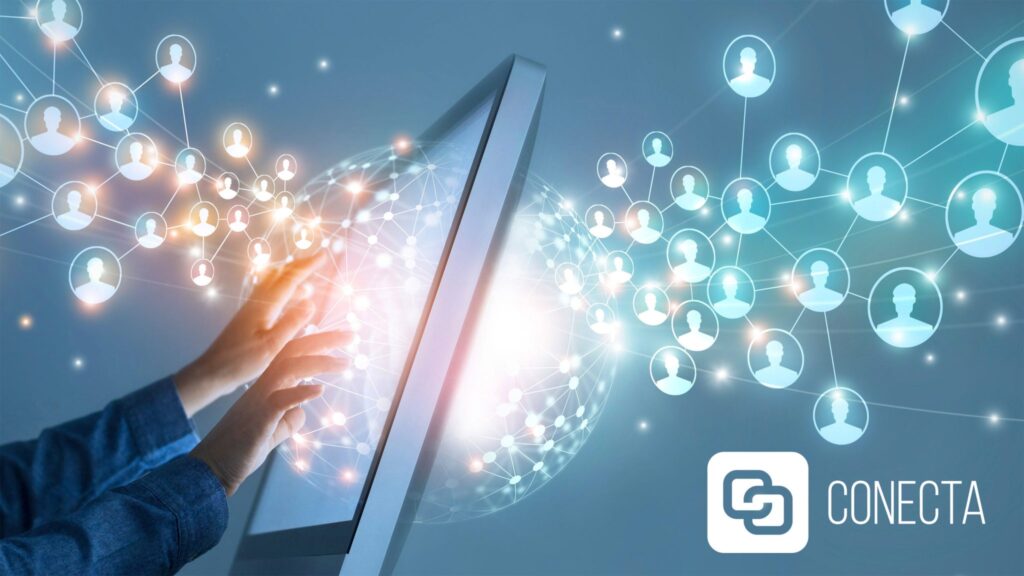 A imagem é uma arte digital de um ambiente tecnológico. Há um fundo com tonalidades de azul, com representações de uma rede de conexões e ícones de perfis de pessoas. Na parte inferior, duas mãos tocam uma tela inclinada, que tem um brilho no centro. No canto inferior direito, o logo da "CONECTA", com a letra 'C' em um formato que lembra uma conexão ou elo.
