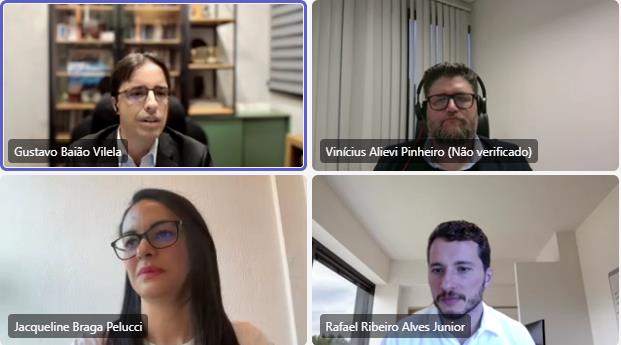 A imagem é um print de uma videochamada com quatro participantes. A tela está dividida em quatro quadrados.

No canto superior esquerdo está "Gustavo Baião Vilela", um homem de óculos e terno escuro.
No canto superior direito está "Vinícius Alievi Pinheiro", um homem barbudo com óculos e fones de ouvido.
No canto inferior esquerdo está "Jacqueline Braga Pelucci", uma mulher de óculos.
No canto inferior direito está "Rafael Ribeiro Alves Junior", um homem com barba.